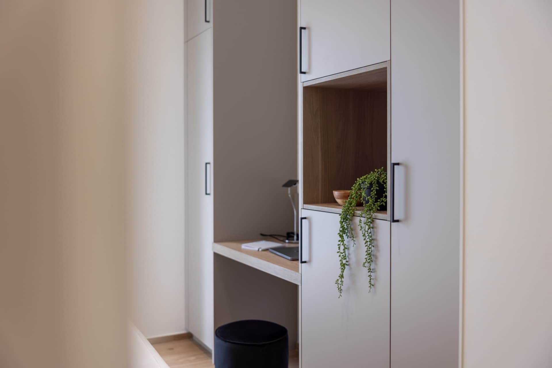 The picture depicts a close-up angle of the working area, showing a desk with a laptop, notebook and a lamp on it.
Attached, are storage rooms and dressings.