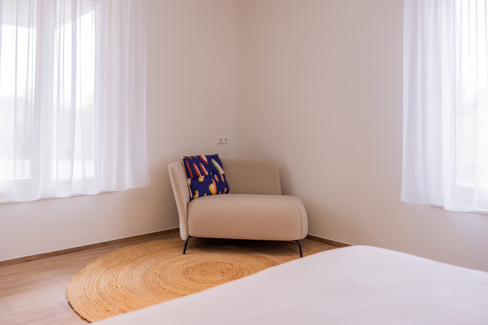 Close-up picture of the beige armchair in the furnished bedroom for rent.