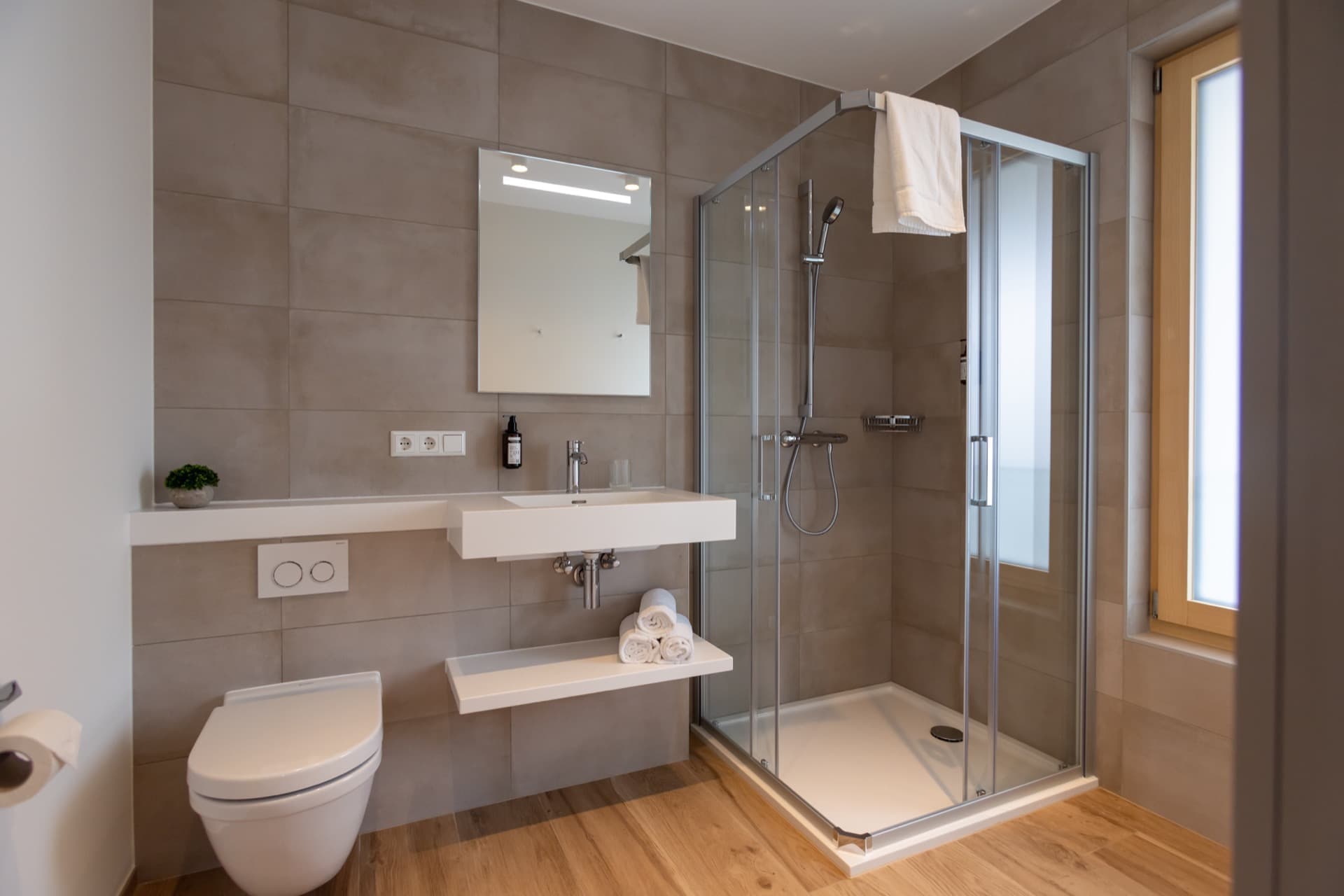 Overview of the en-suite bathroom of a furnished bedroom. It has a walk-in shower, a sink and a mirror above.
Towels and toiletries are available