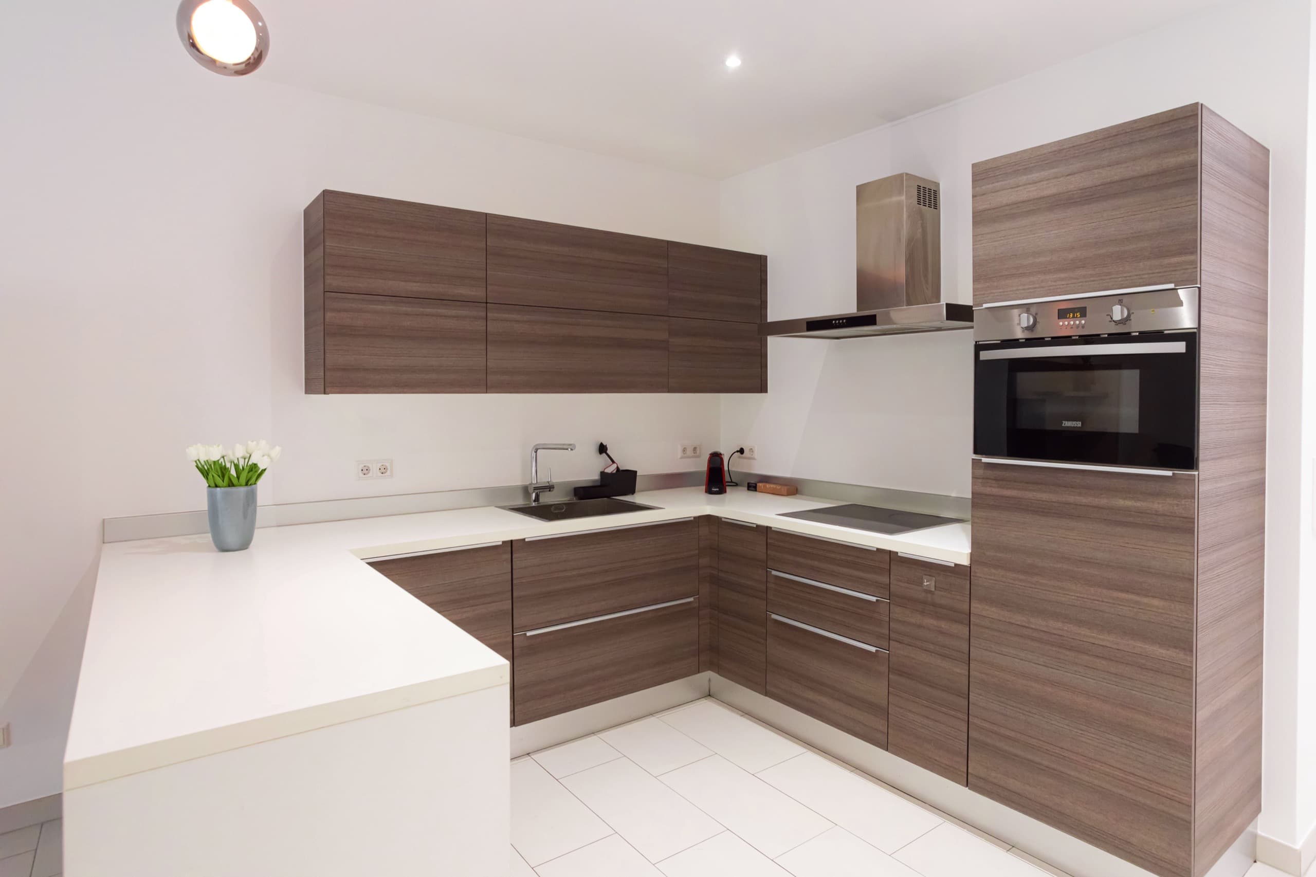 Fully equipped kitchen with a flower vase on the countertop.