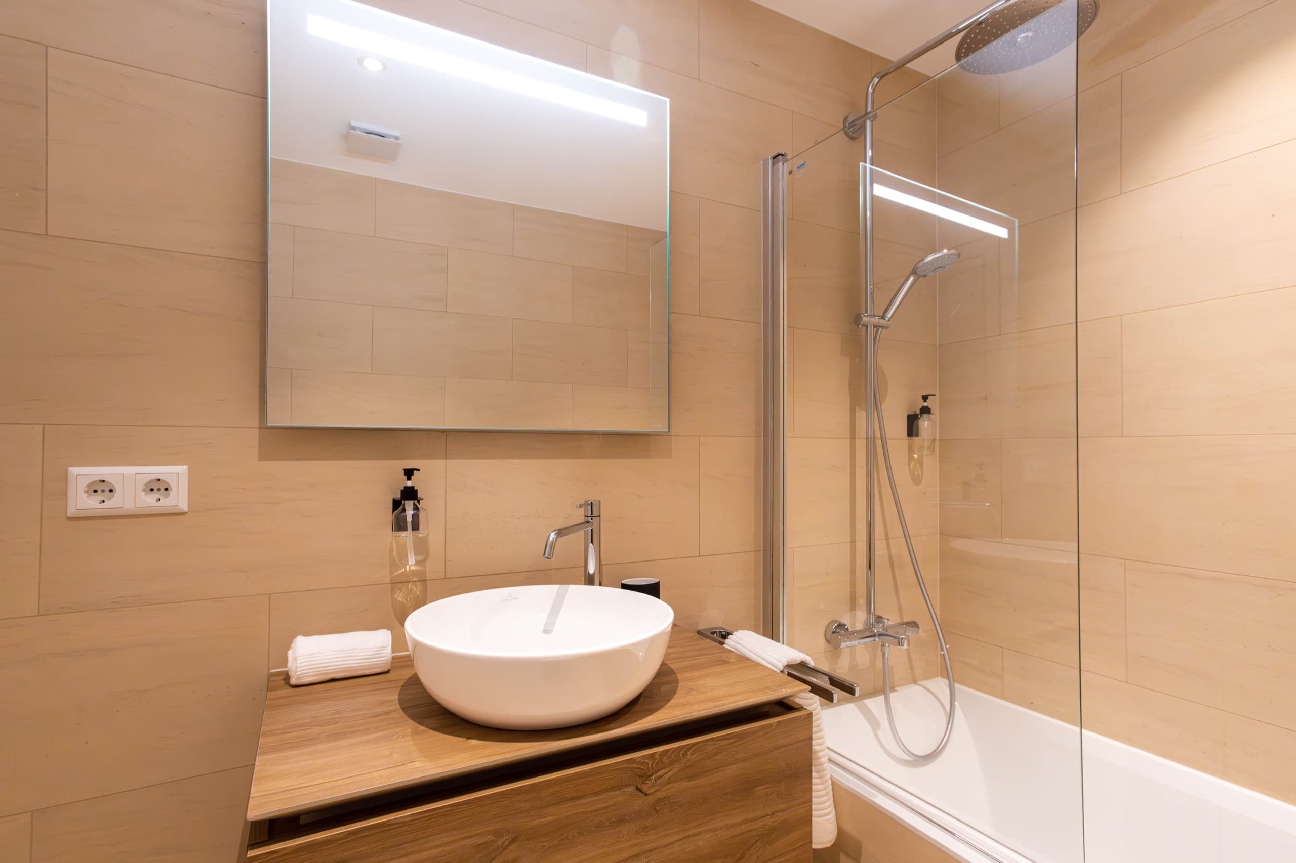 Bathroom with bath and sink. Above the sink, there is a cabinet with mirror doors. Soap and towels included