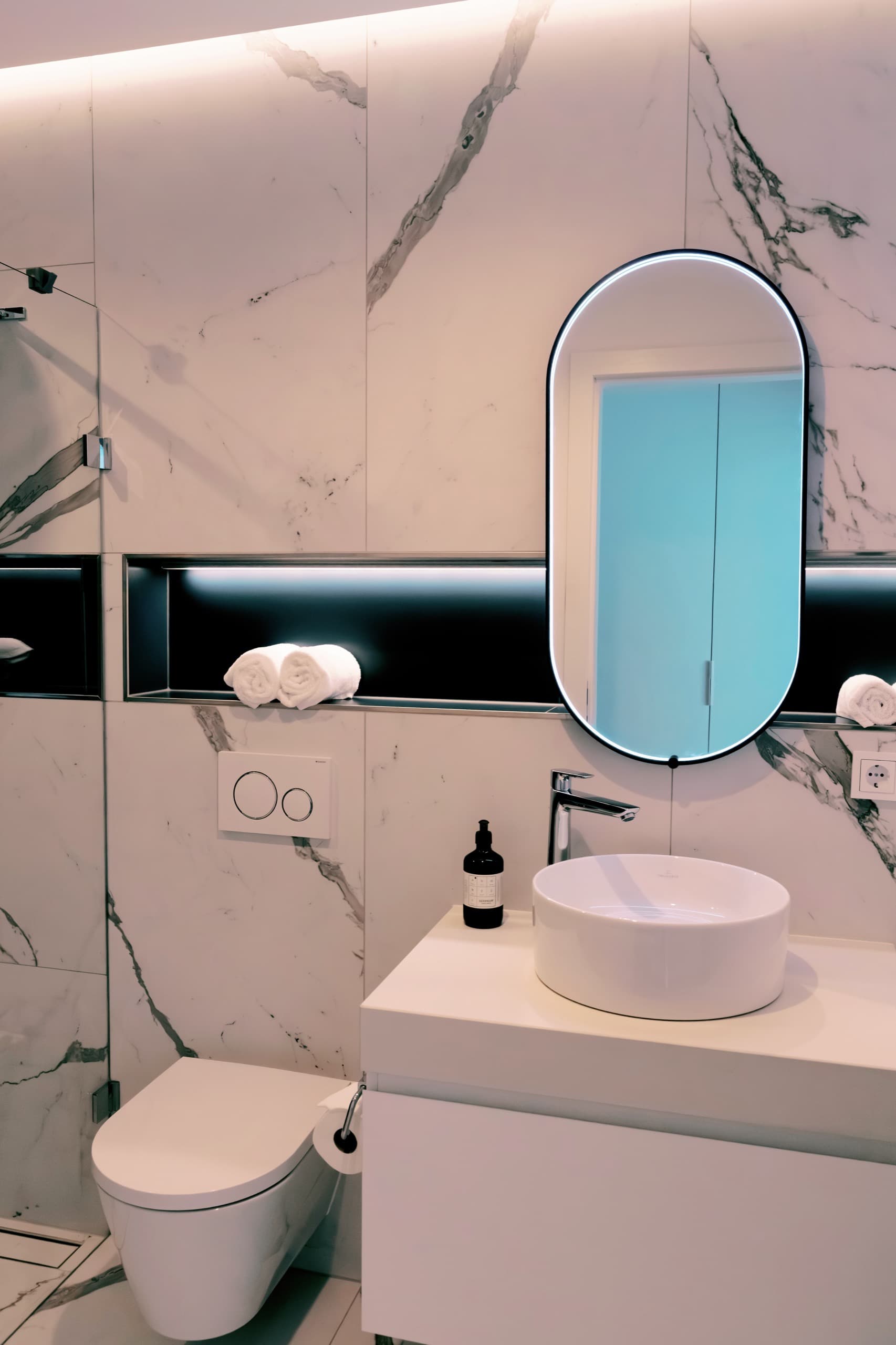 Bathroom with toilet, sink, towels, and snuff. Towels, soap, and other amenities in the drawers