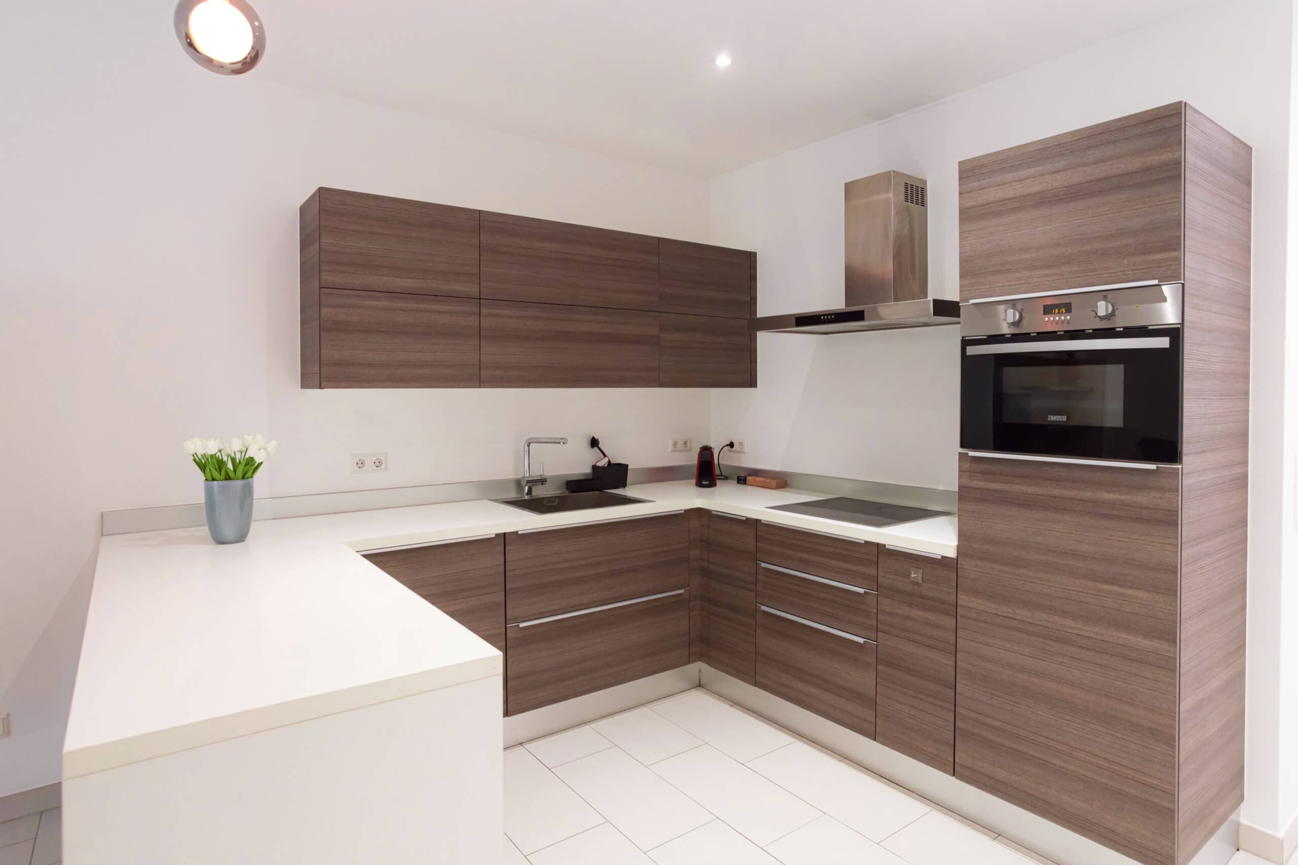 Modern white and brown kitchen with stove, oven and sink