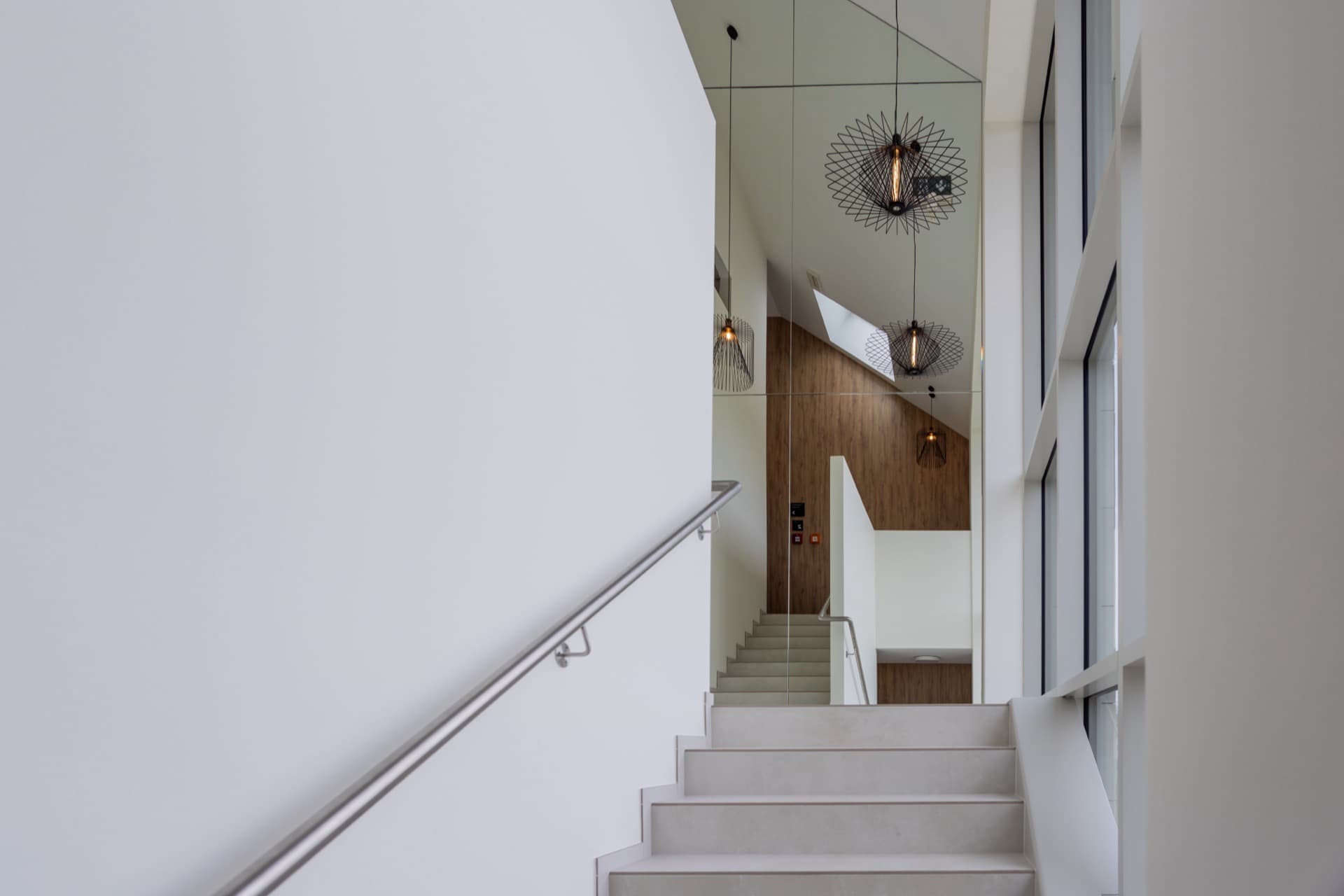 View over the stairs, main entry door and other doors from the house. Large windows on the hallways provide ample natural light