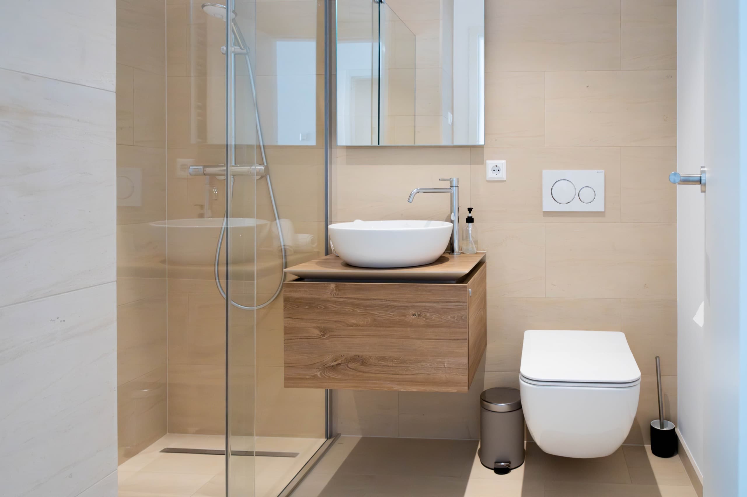 Bathroom with shower cabin, white sink, and toilet. All amenities included
