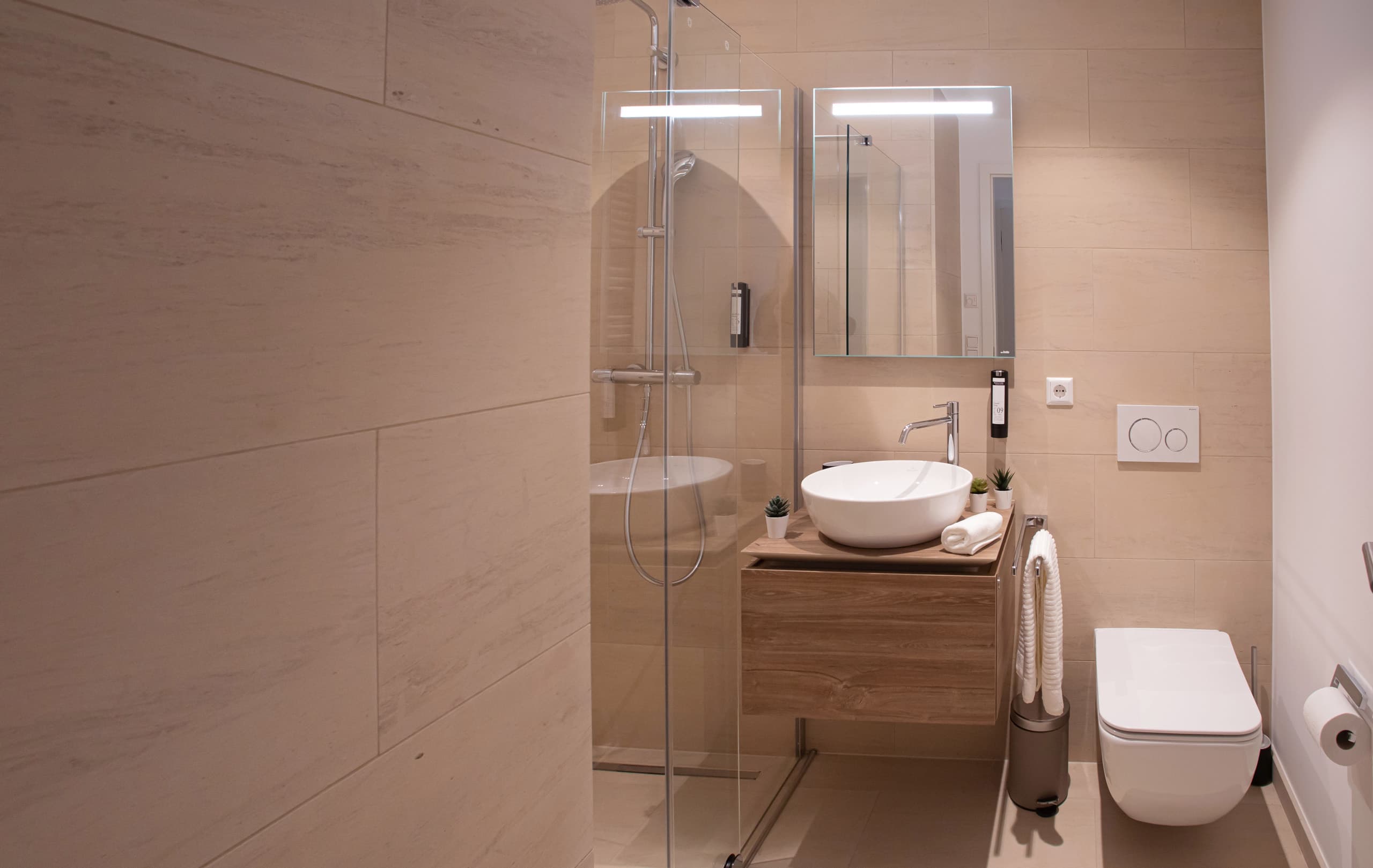 Bathroom with shower cabin, sink, and toilet. All amenities included.